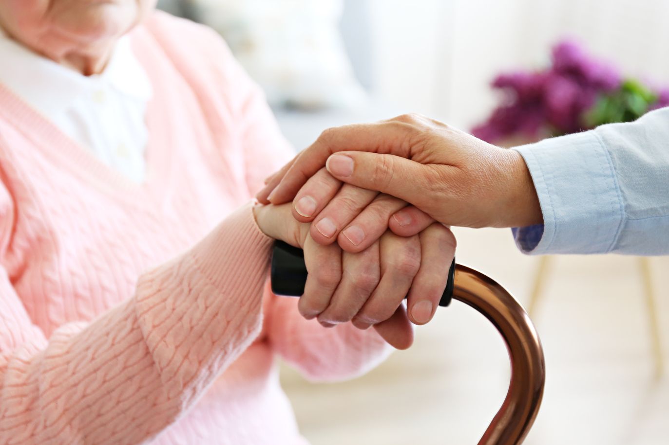 Pflegerin hält die Hand der Patientin